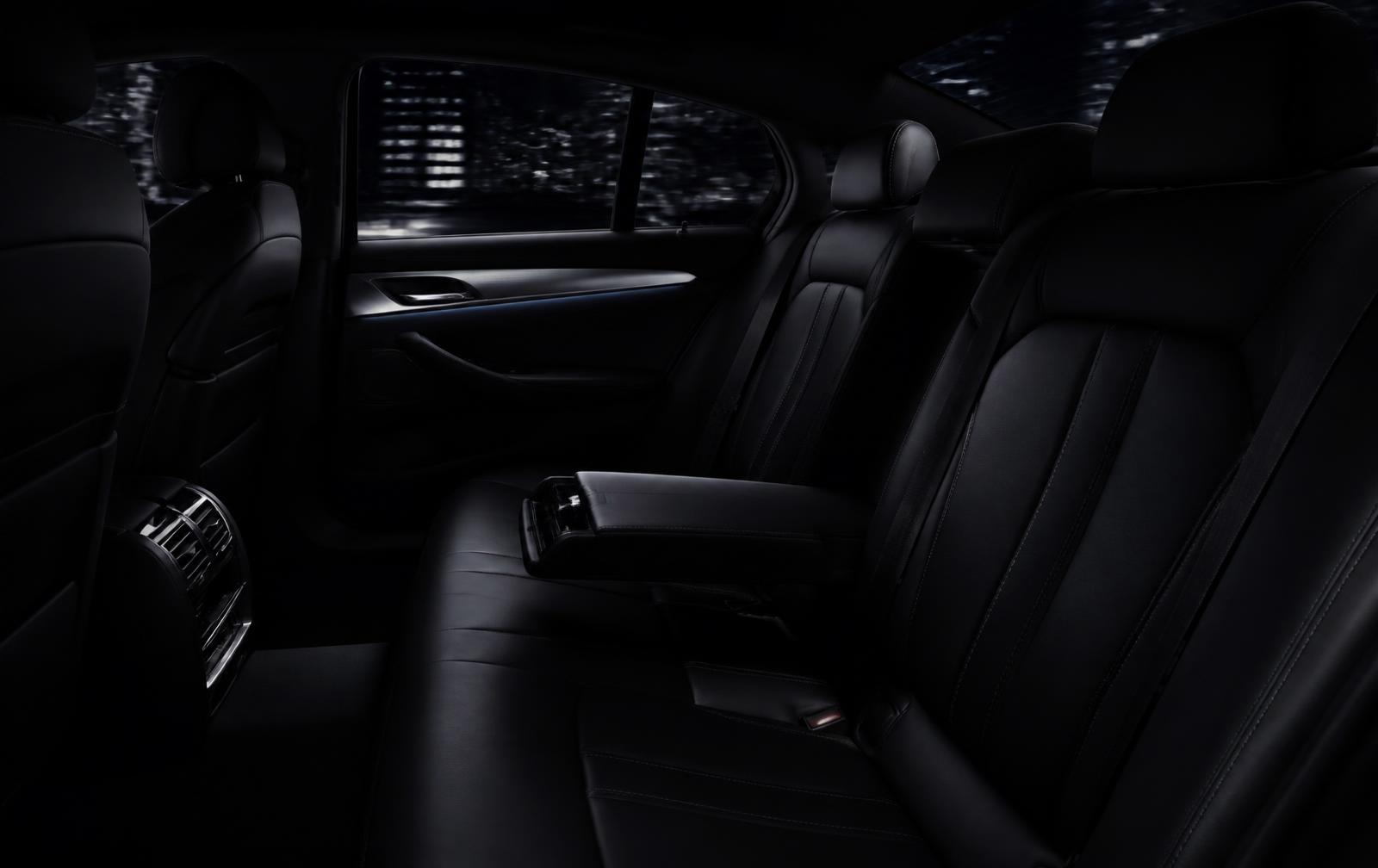 Quiet rear cabin of a black executive sedan at night