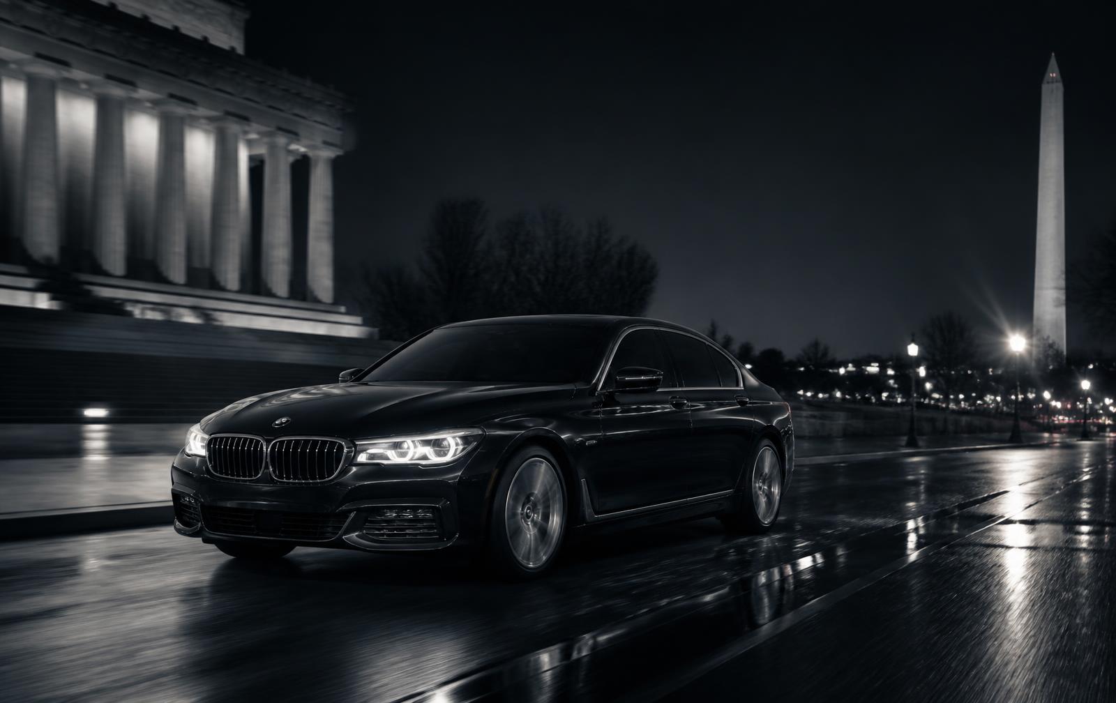 Black executive sedan on a wet Washington DC avenue at night